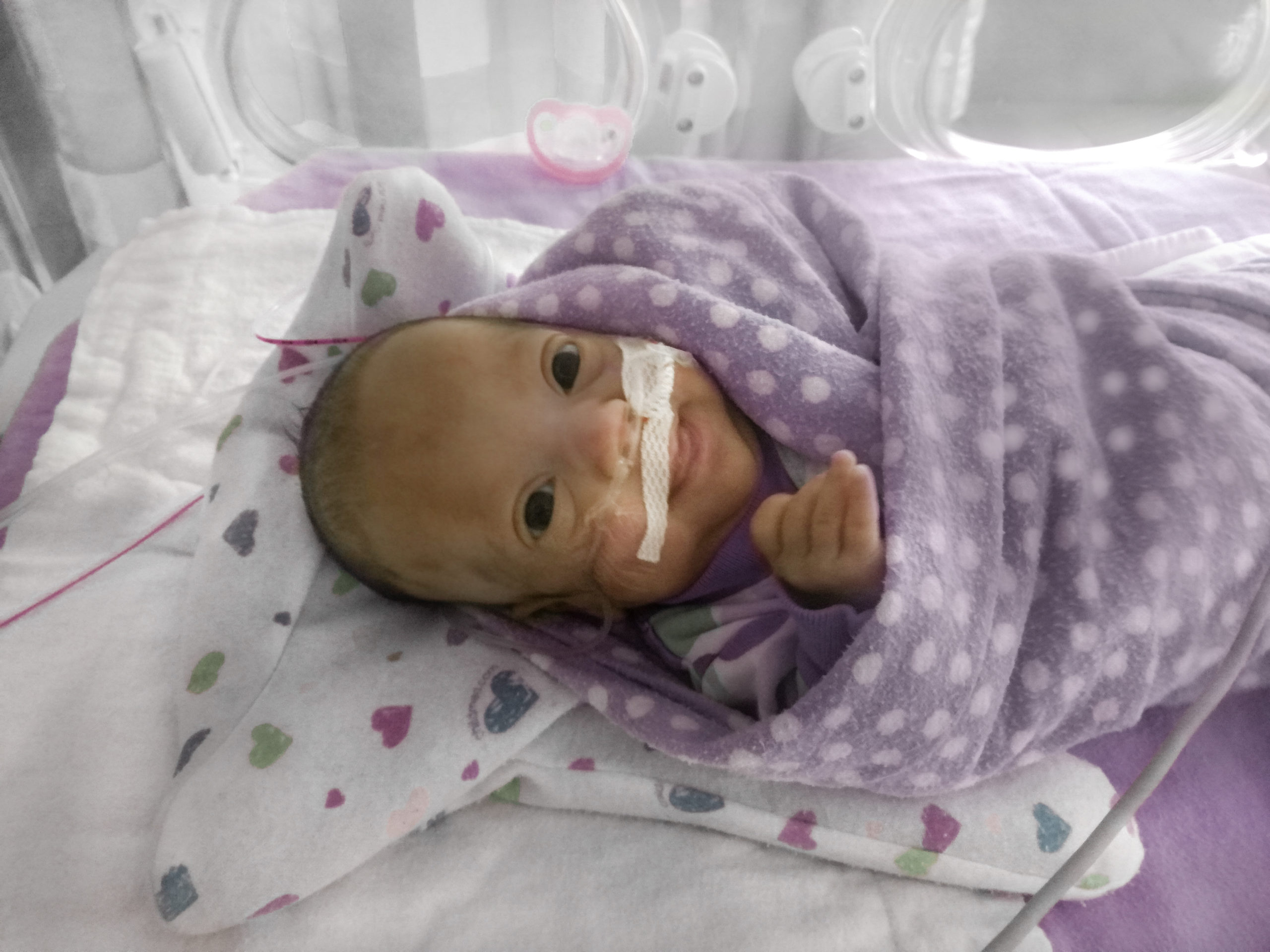 Baby Jenna wrapped in a blanket in the NICU
