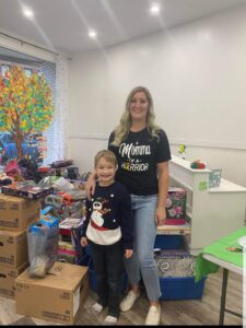 Nolan and Sarah in a room surrounded by donated gifts.