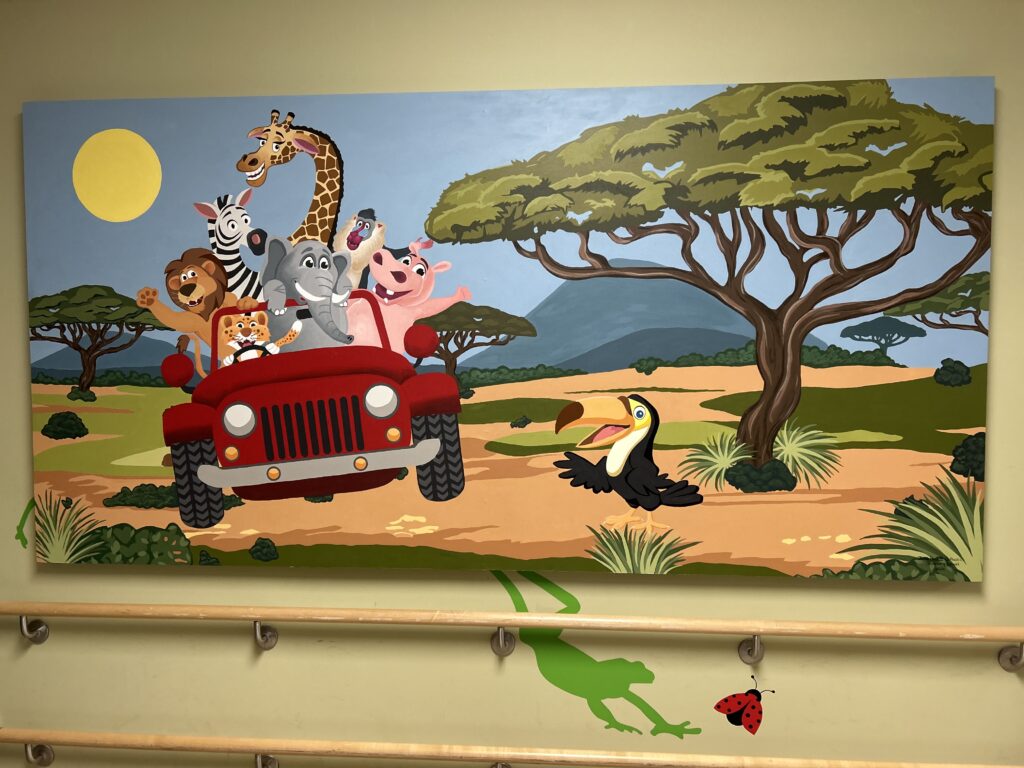 A mural depicting animals commonly seen on safari driving a jeep through African savannah.