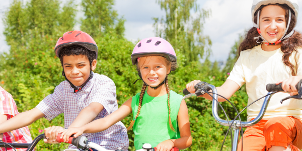 three kids wearing bike helmets