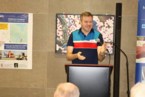 Darren McEwen speaking at a lectern.