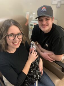 A young mother and father pose with their premature infant, who is using a ventilator to breathe.